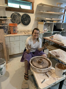Girl having fun at pottery wheel