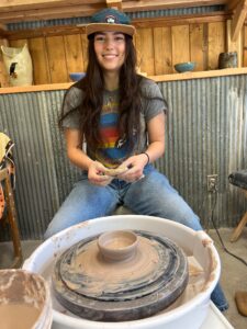 Girl learning pottery on the wheel