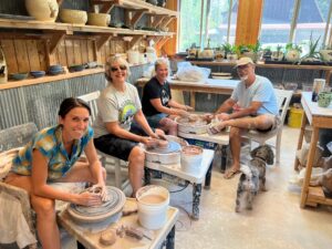 People doing pottery on the potters wheel