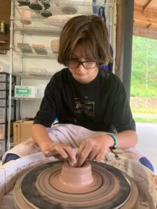 Meditative kid on the pottery wheel