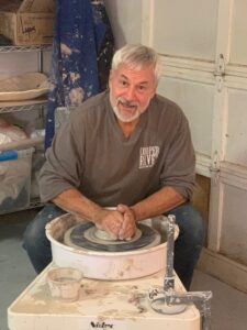Jim Quick sits at the pottery wheel