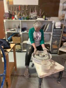 Old woman at pottery wheel